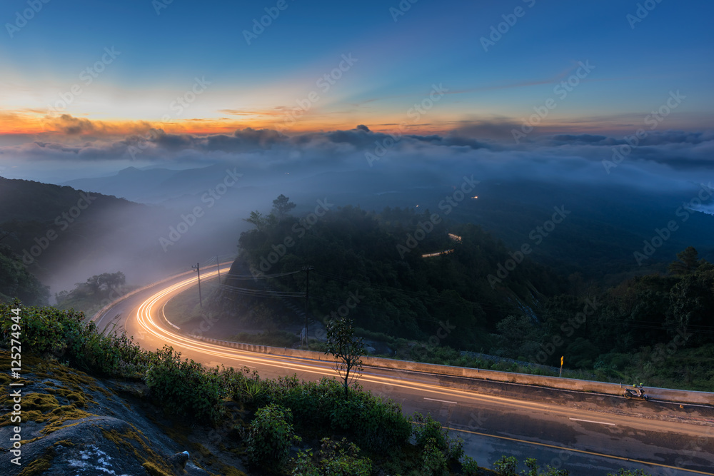 Lights up road to a big mountain with hazy weather and sunrise sky