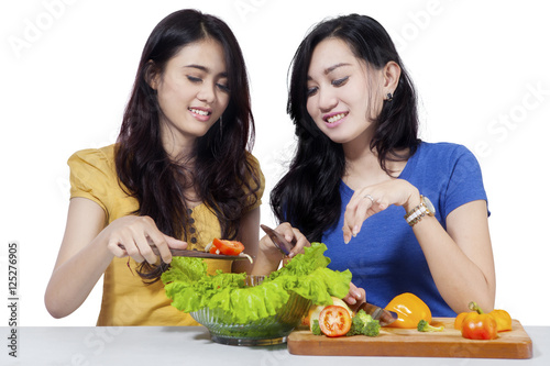 Two woman makes salad together