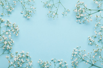 Wedding flower frame on blue background from above. Beautiful floral pattern. Flat lay style.