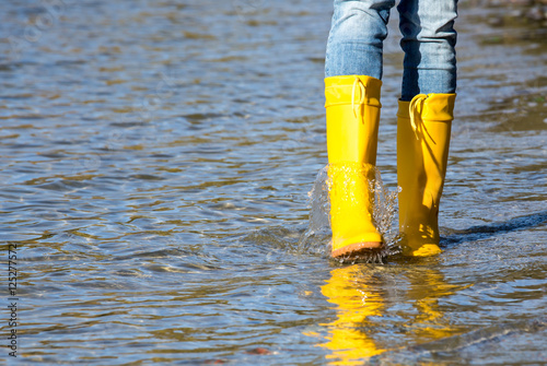 On a sunny day with rubber boots running through water 