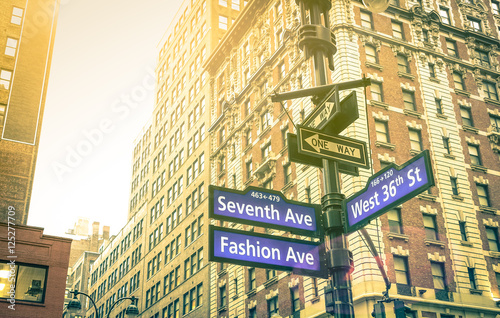 Street sign of Seventh and Fashion Ave with West 36th St at sunset in New York City - Urban concept and road direction in Manhattan - American world famous capital destination on warm vintage filter