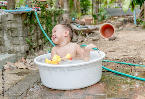 Top view Asian baby boy outdoor bathing in the white bathtub . H