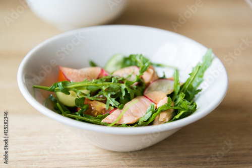 Hot meat salad with fresh radish in white plate