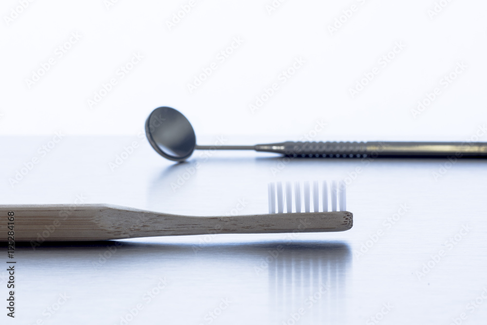 A tooth brush and a mouth mirror A tooth brush and a mouth mirror