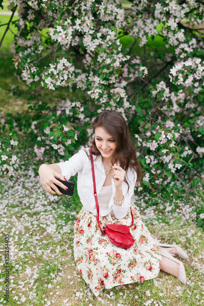 young woman using a mobile phone to take selfie outdoor. young woman using a mobile phone to take selfie outdoor.