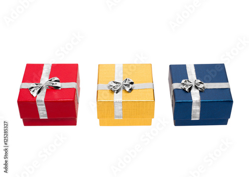 Three gift boxes red, golden and blue with a silver ribbon isolated on a white background