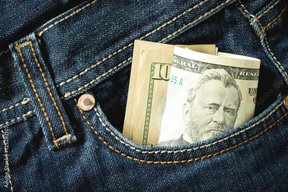 US dollars rolled in a jeans pocket US dollars rolled in a jeans pocket
