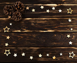 Wooden background with christmas wooden stars folded on the perimeter and 
cones. Place for text