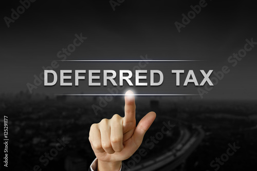 business hand pushing deferred tax button