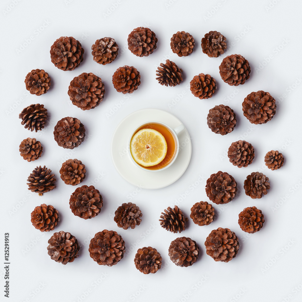 Tea cup with pine corn on white background. Winter concept. View from above. Flat lay Tea cup with pine corn on white background. Winter concept. View from above. Flat lay