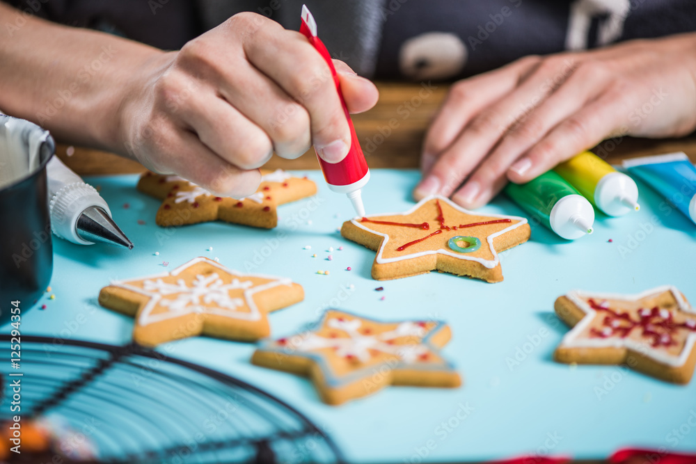 woman decorating gingerbread Christmas cookies woman decorating gingerbread Christmas cookies