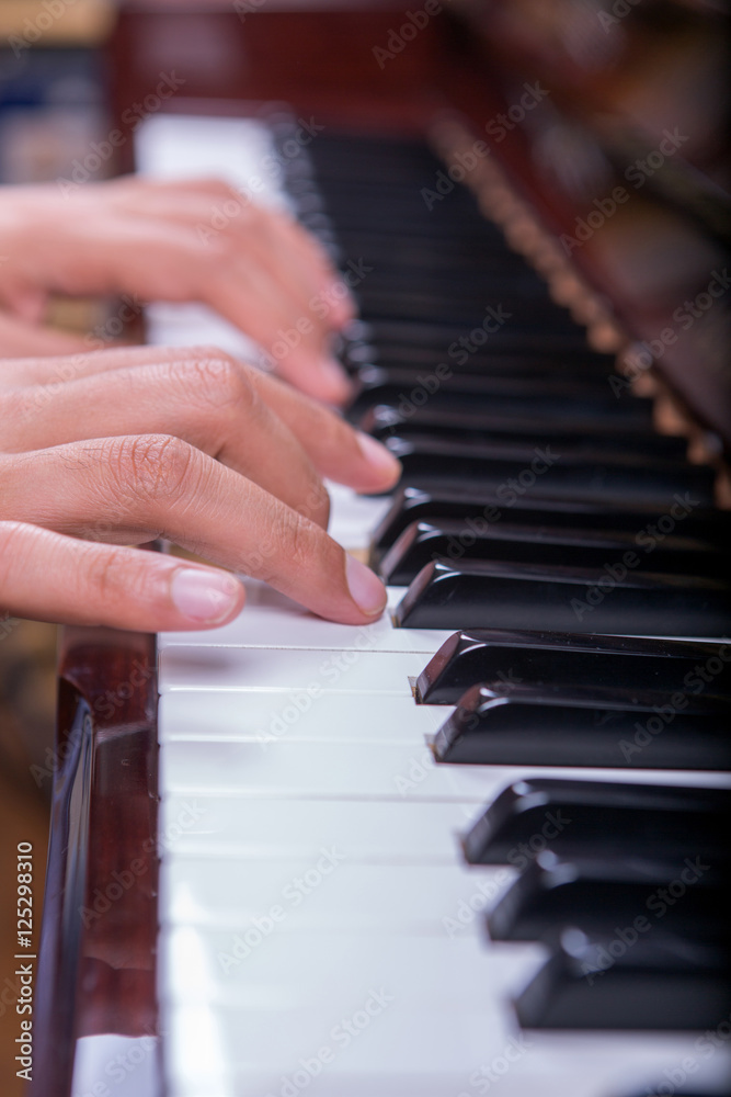Fototapeta premium Man playing piano with both hands portrait view