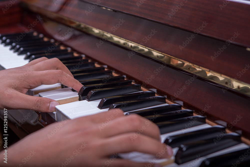 Obraz premium Man playing piano with both hands side view