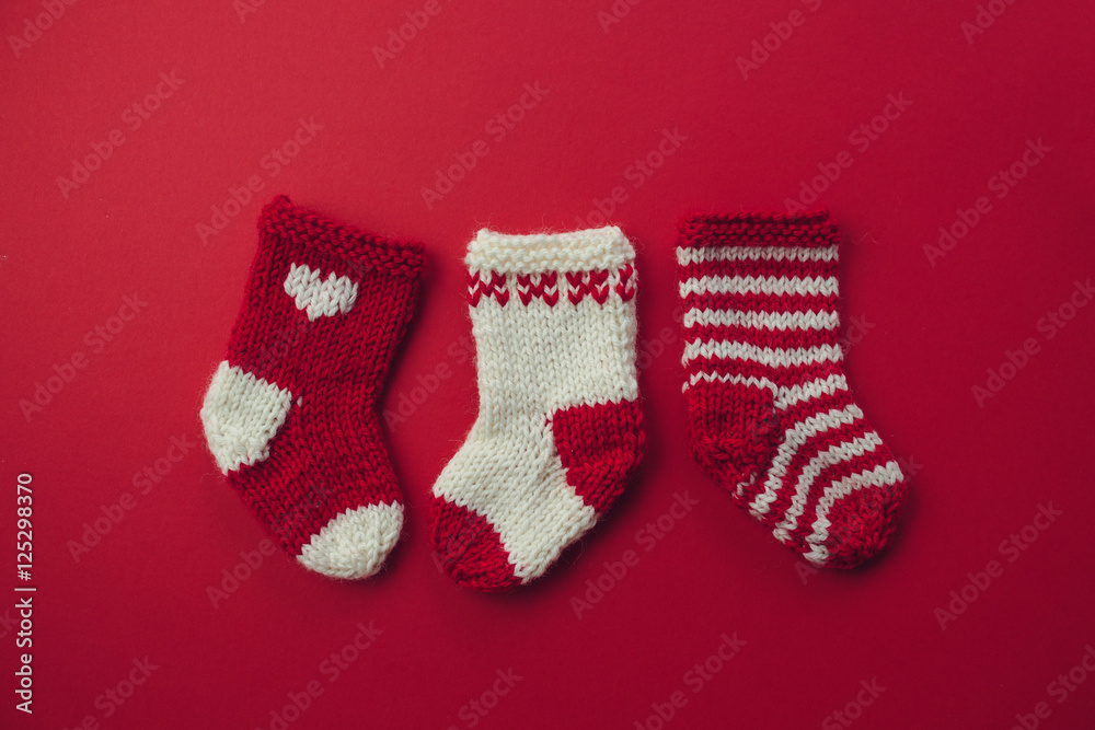 Mini Christmas Stockings.Three red and white wool Christmas stockings on red background. Mini Christmas Stockings.Three red and white wool Christmas stockings on red background.