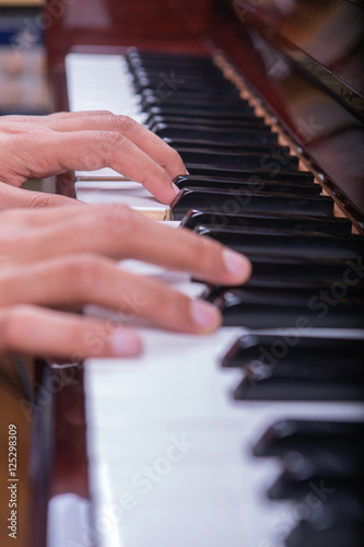 Man playing piano with both hands portrait view 2