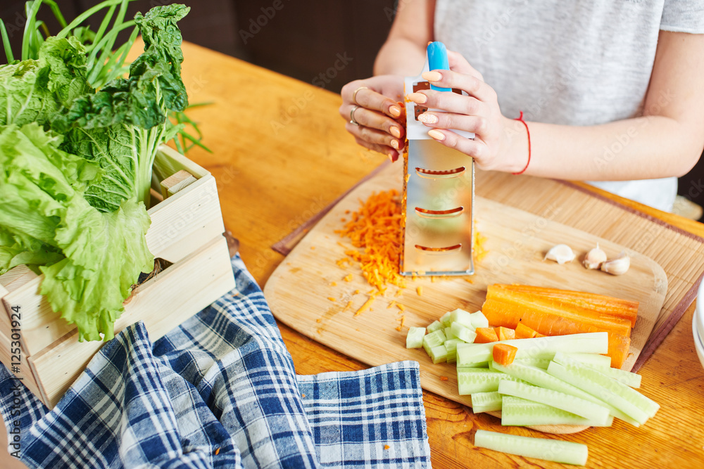Female hand grate the carrots on a wooden Board Female hand grate the carrots on a wooden Board