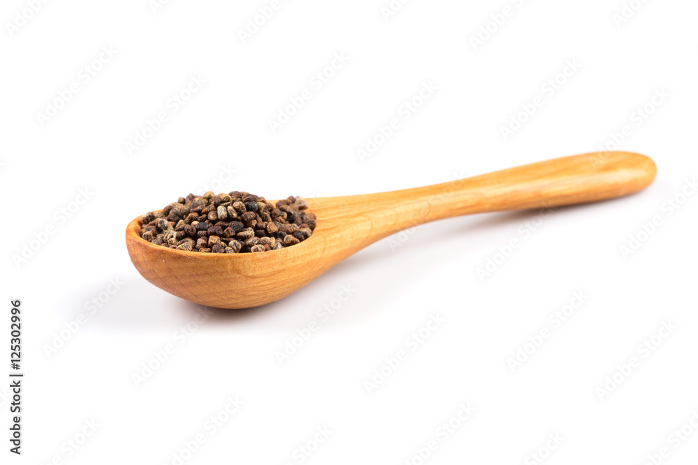 Decorticated cardamom seeds in a wooden spoon