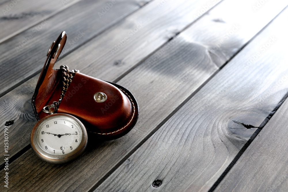 Picture of a antique pocket watch with case of old wood background