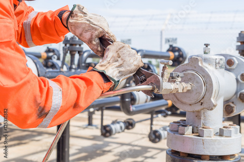 Close-up image of human hand fixing and stop leak stainless tube by wrench in oil and gas process
