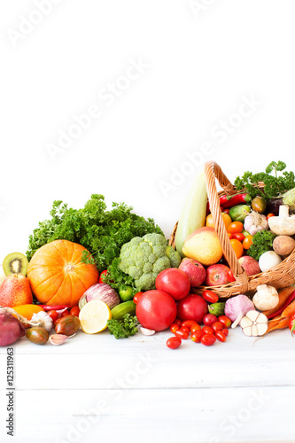 Basket with vegetables on a wooden background.