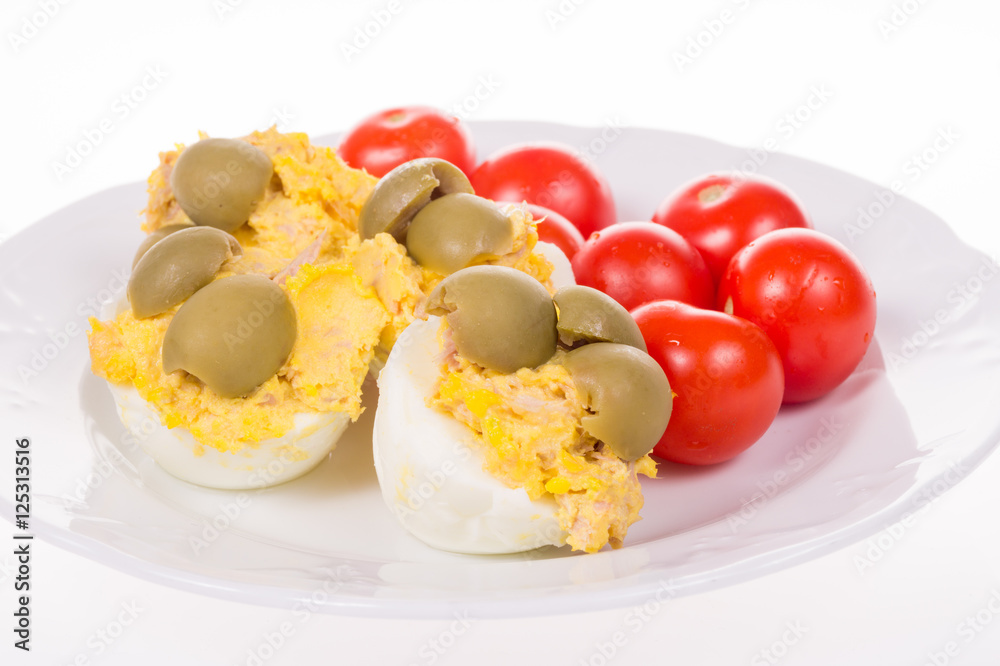 stuffed eggs and red little tomatoes on a pot stuffed eggs and red little tomatoes on a pot