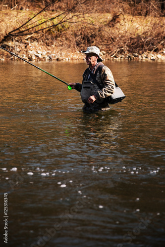 Adult fisherman catching grayling