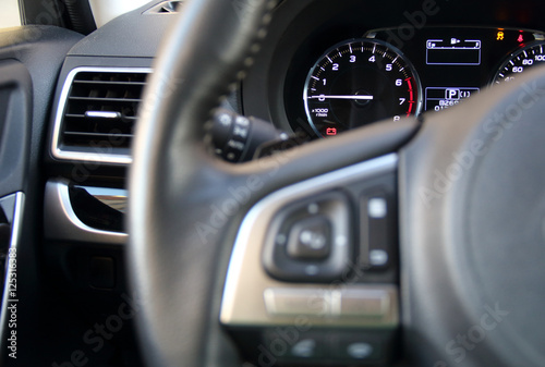 Controls on steering wheel and illuminated dashboard inside the vehicle  © AnyVIDStudio