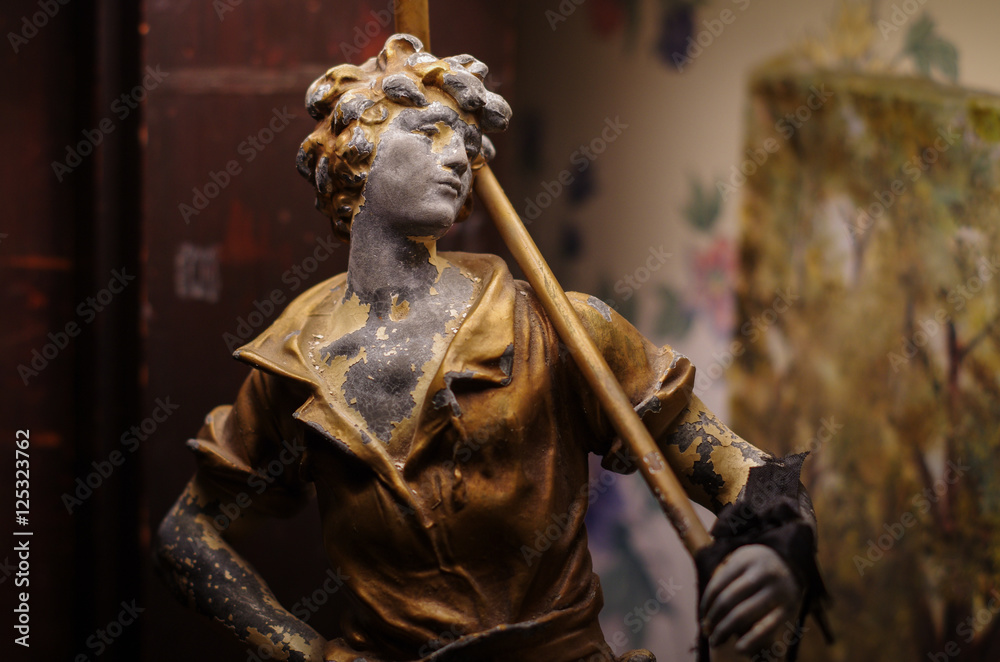 Obraz premium Painted Metal Statue of Boy on Bookshelf