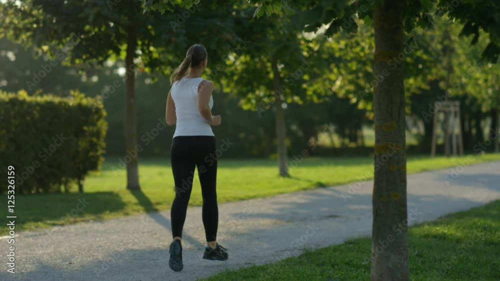 SLOW MOTION: Young sporty woman running in amazing tree promenade in green park SLOW MOTION: Young sporty woman running in amazing tree promenade in green park