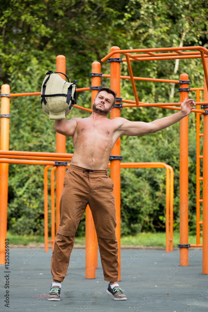 Obraz premium Man Performing Bag Squat Exercise Outdoor