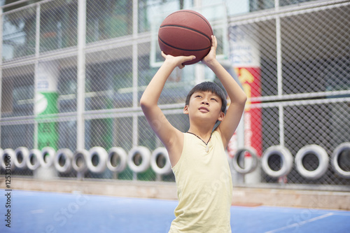 boy preparing for shooting at basketball court © allensima
