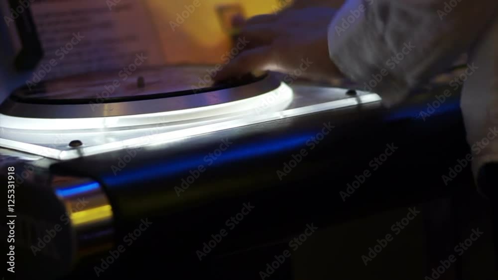 Young man playing Dj music game at arcade Young man playing Dj music game at arcade