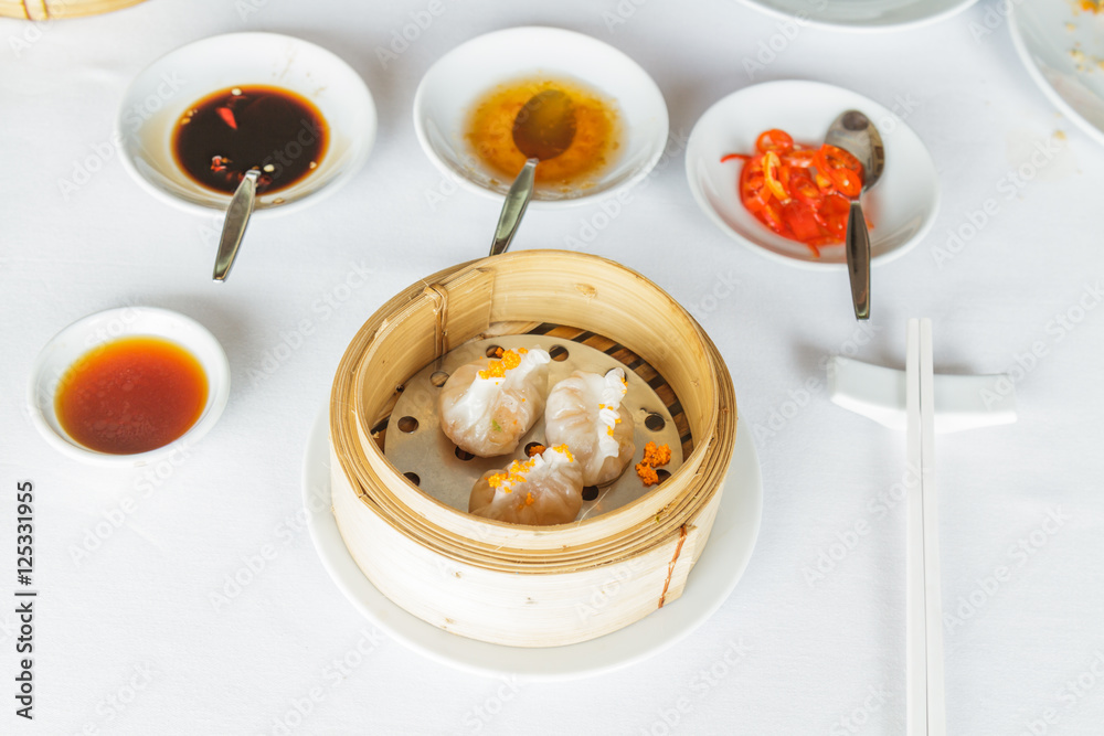 Dim sum food Steamed shrimp Fun Goh dumpling in bamboo basket at