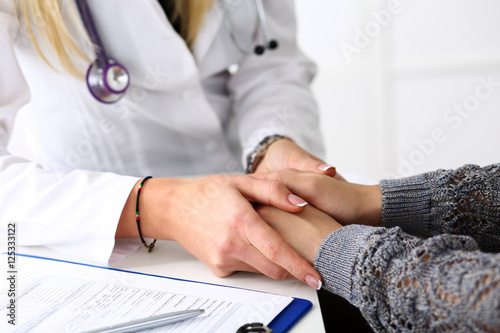 Friendly female doctor hold patient hand photo