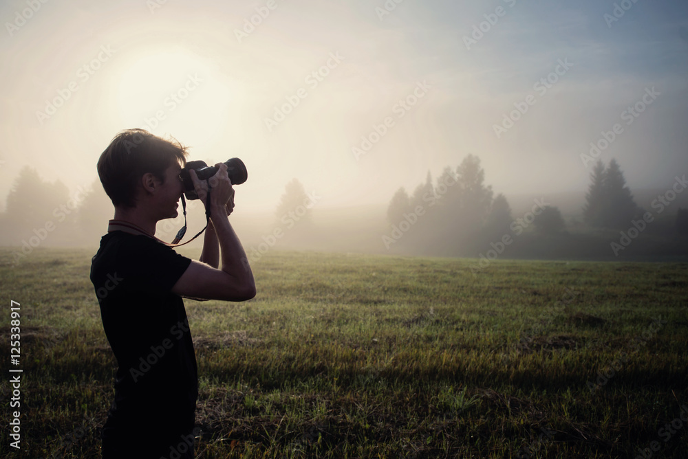 photographer in the fog taking a picture of the landscape photographer in the fog taking a picture of the landscape