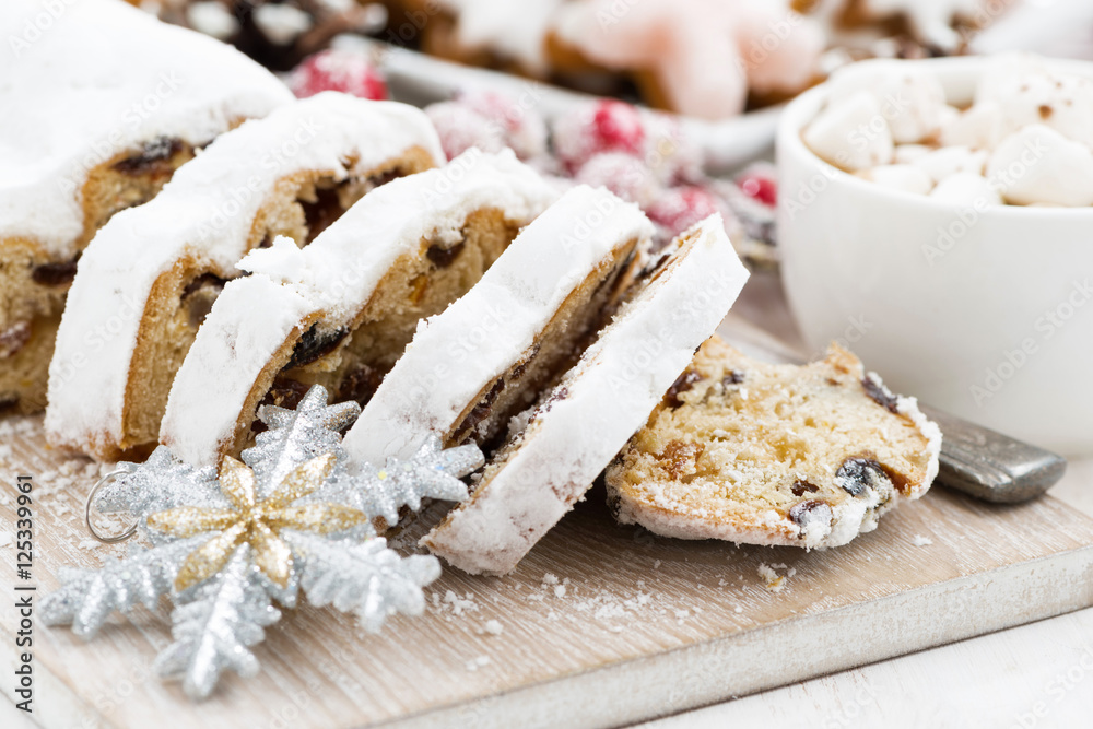 Christmas Stollen on a wooden board and sweets, closeup