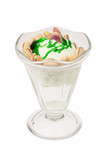 Ice cream cup with green cream, topping and cookies.