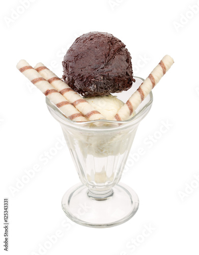 Creamy sundae ice cream in cup with wafer rolls.