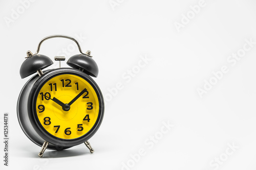 Black vintage retro style alarm clock on white background and selective focus