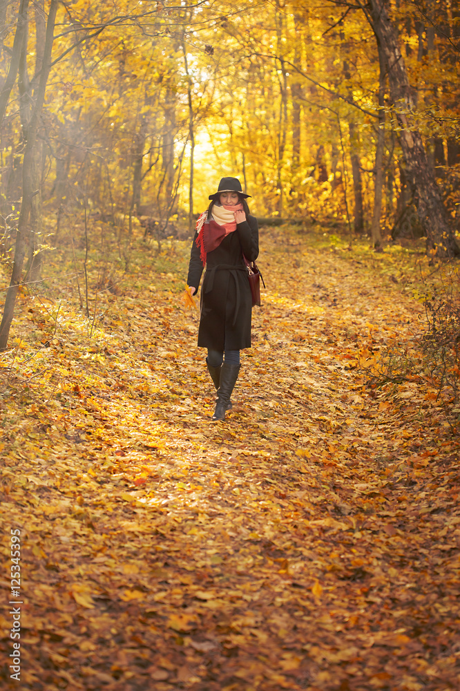beautiful young woman walking in autumn forest