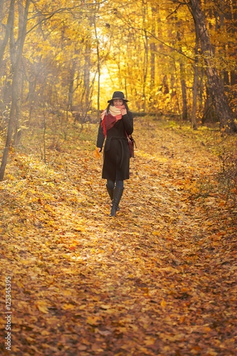 beautiful young woman walking in autumn forest © tugolukof