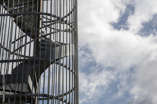 Section of steel staircase with blue sky with clouds as background