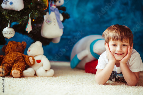 Little boy is lying on the white carpet