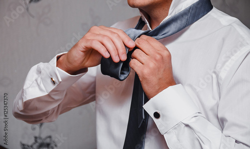 Foto male businessman tying tie