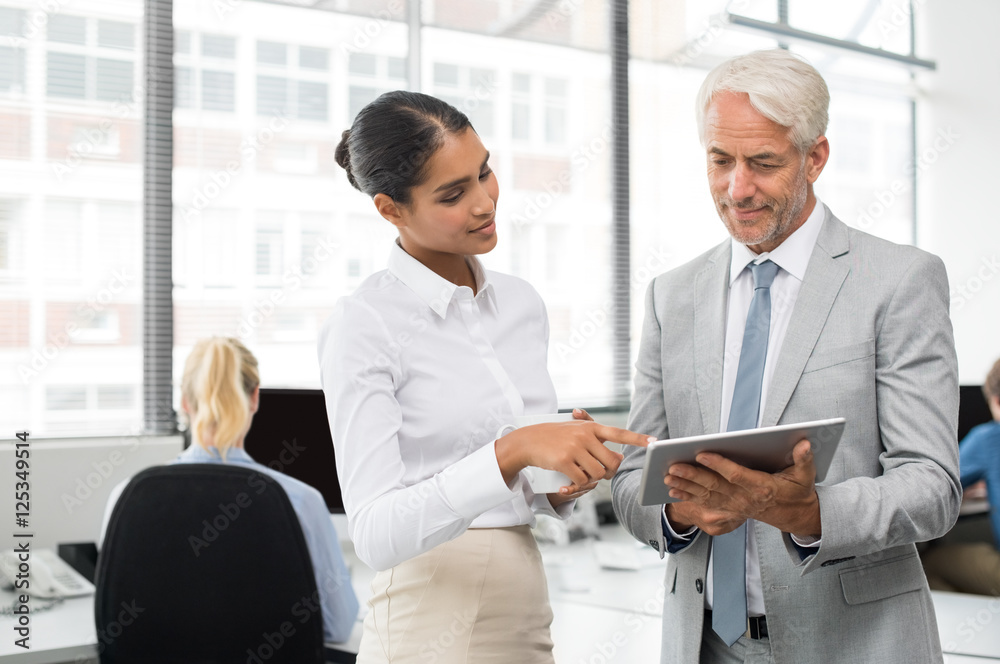 Assistant helping senior businessman Assistant helping senior businessman