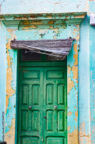 Verwitterte Fassade mit grüner Holztüre auf Gozo, Malta © foodolia