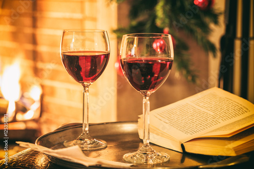 Two glasses of wine near a fireplace