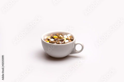 Medical capsules and tablets inside coffee cup