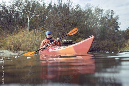 Men travel by canoe on the river.