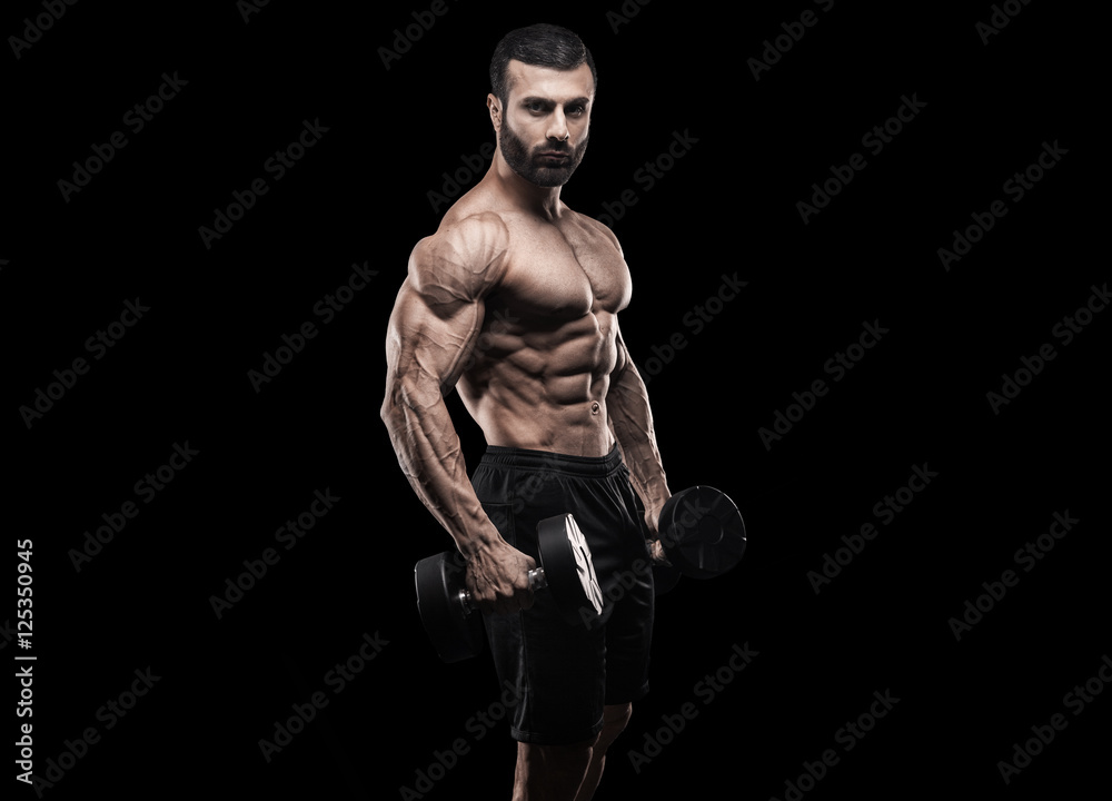 Handsome man with big muscles, posing at the camera in the gym Handsome man with big muscles, posing at the camera in the gym